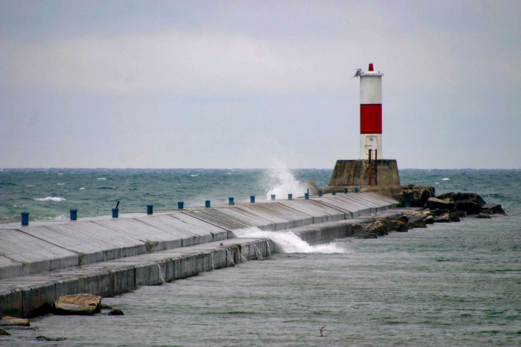 waves crashing over the breakwall